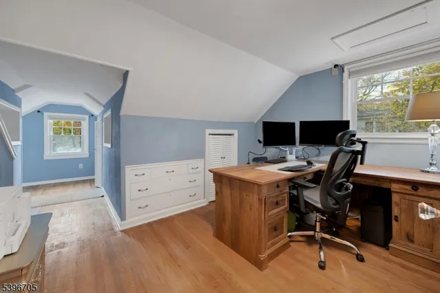a view of a workspace with furniture and a window