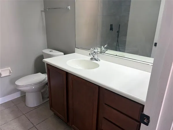 a bathroom with a sink a toilet and a mirror