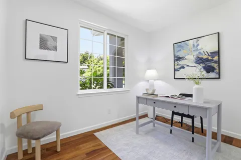 a view of a workspace with furniture and a window