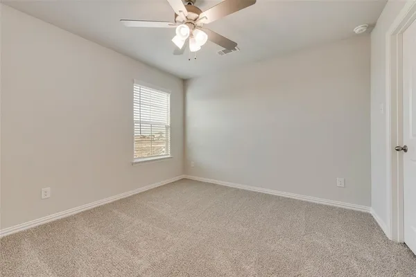 an empty room with a window and a fan