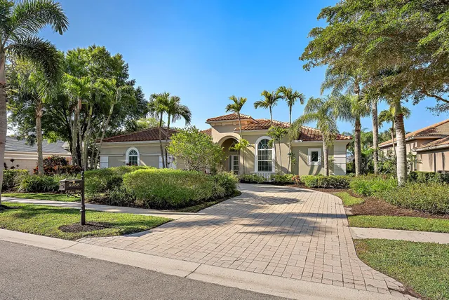 a front view of a house with a yard and potted plants