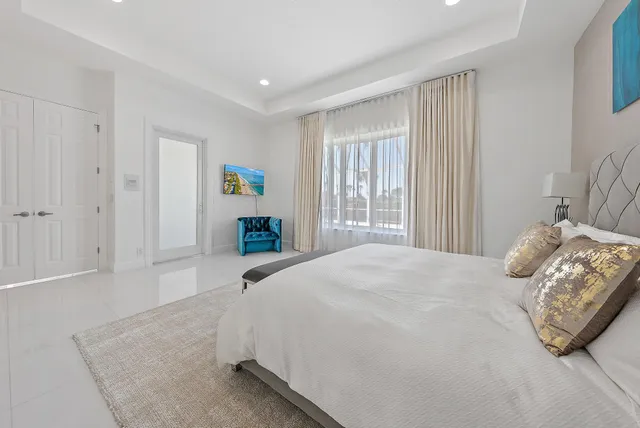 a bedroom with a bed windows and wooden floor