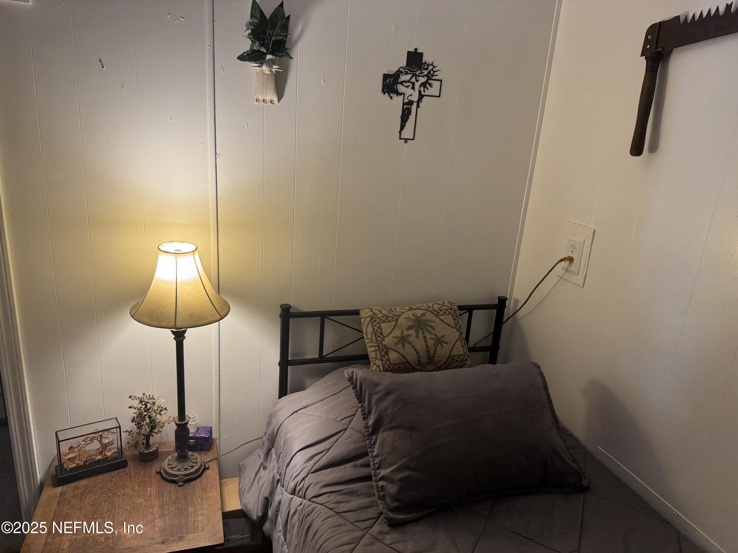 208 Lakeview Road Melrose, FL 32666 - Photo 11 of 22 a bedroom with a bed and a chandelier