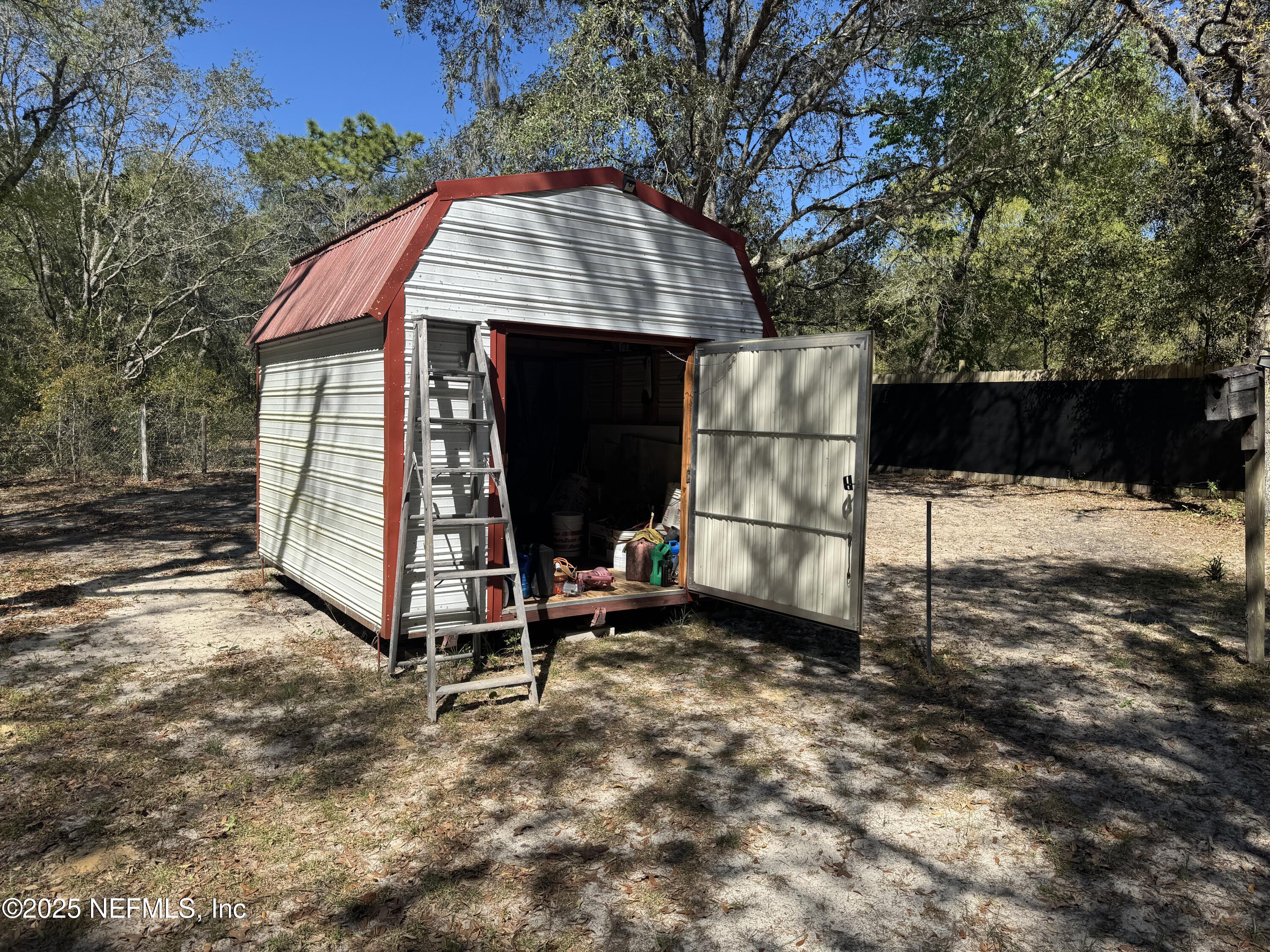 208 Lakeview Road Melrose, FL 32666 - Photo 19 of 22 a view of backyard with a barn and a large tree
