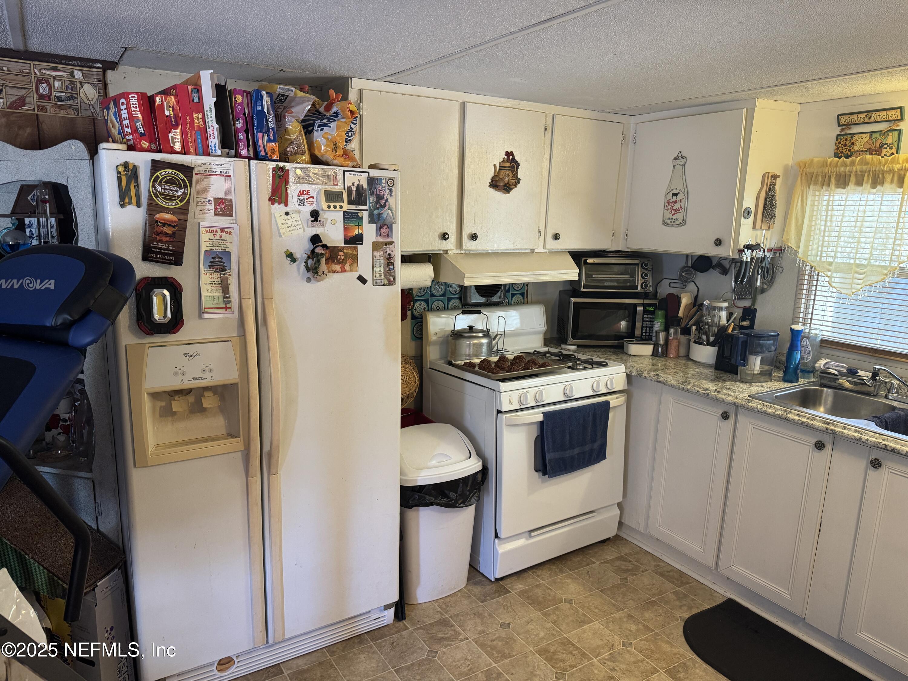 208 Lakeview Road Melrose, FL 32666 - Photo 8 of 22 a kitchen with stainless steel appliances a refrigerator a sink and cabinets