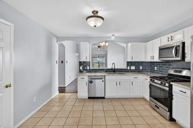 a kitchen with stainless steel appliances granite countertop a sink and cabinets