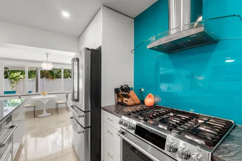 a large kitchen with a large window and stainless steel appliances
