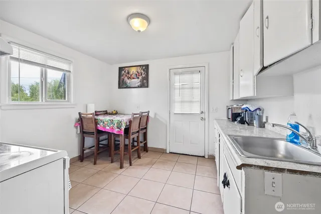 a kitchen with granite countertop a white stove top oven and cabinets