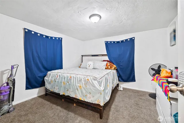 a bed sitting in a bedroom next to a window