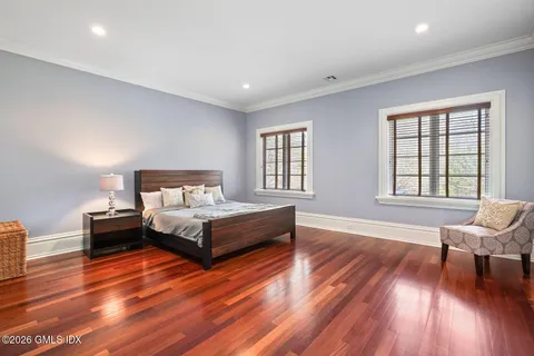a spacious bedroom with a bed and wooden floor