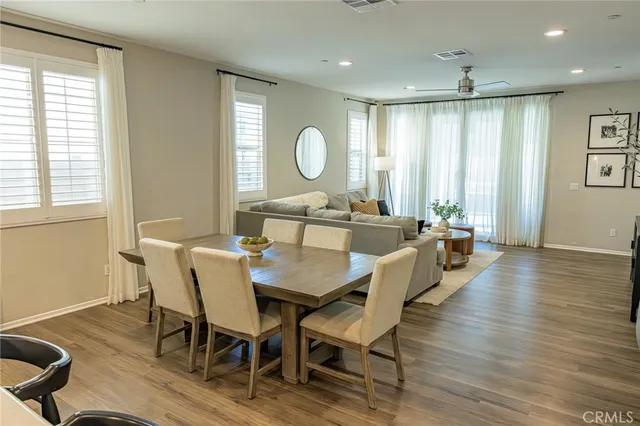 a view of a a dining room with furniture window and wooden floor