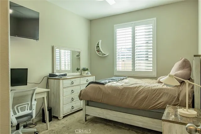 a bedroom with a bed and a flat tv screen on the dresser