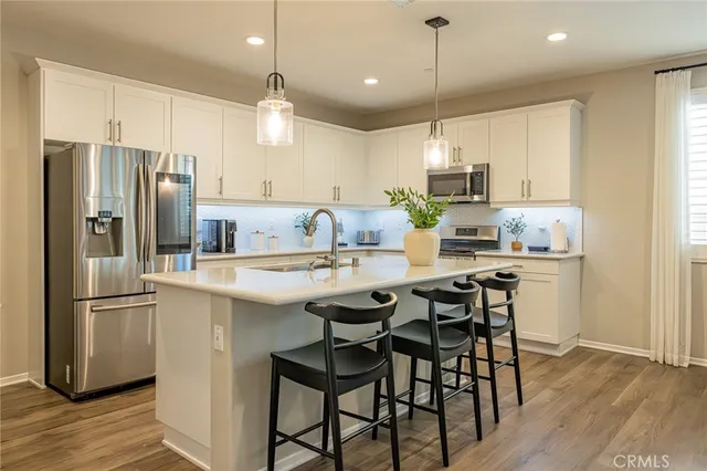 a kitchen with kitchen island granite countertop a sink a center island and stainless steel appliances