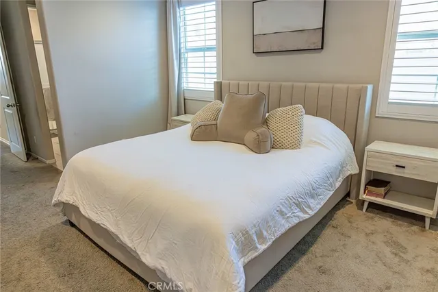 a large bed sitting in a bedroom next to a window