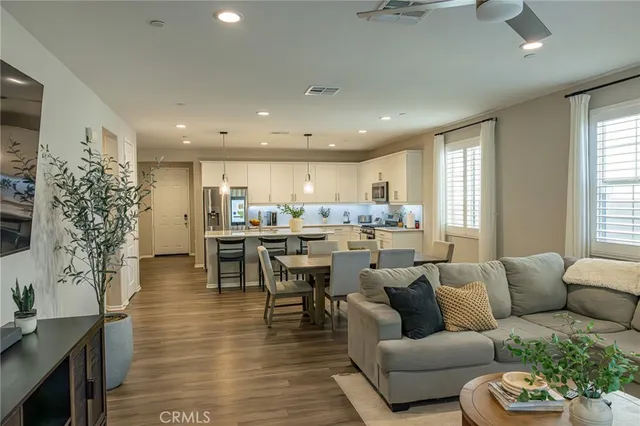 a living room with furniture kitchen and a large window