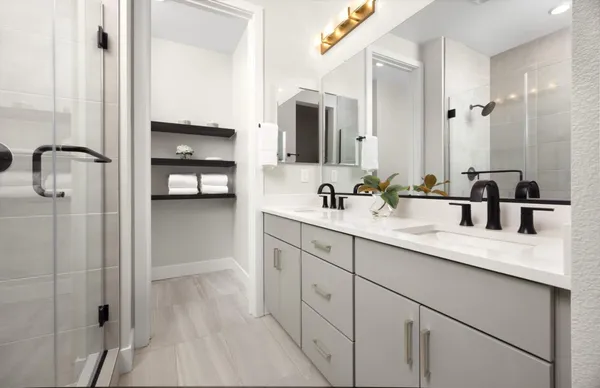 a en suite bathroom with a double vanity sink a mirror and shower