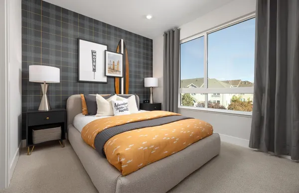 a bed sitting in a bedroom next to a window