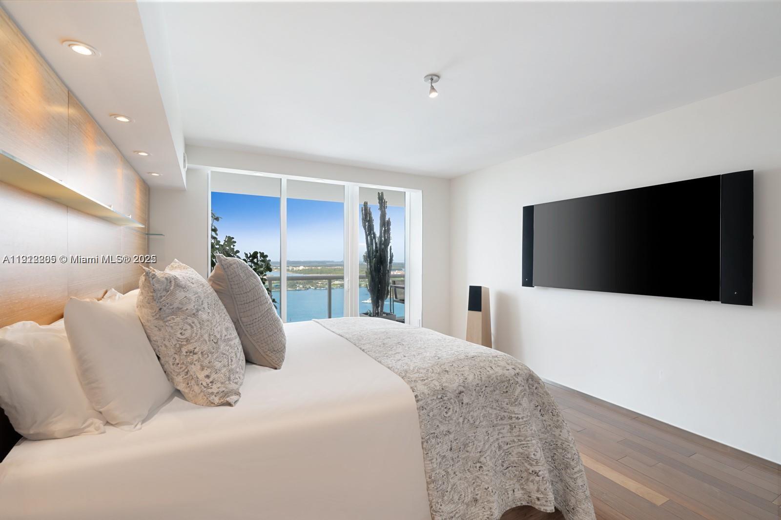 450 Alton Road, Unit 3303 Miami Beach, FL 33139 - Photo 11 of 35 a bedroom with a large bed and a flat screen tv