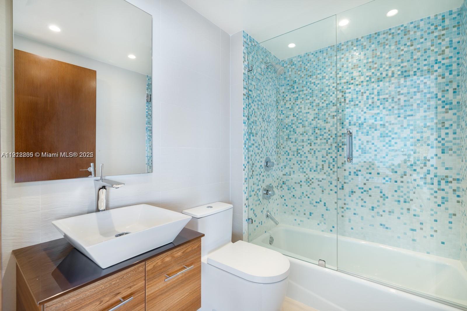 450 Alton Road, Unit 3303 Miami Beach, FL 33139 - Photo 12 of 35 a bathroom with a sink toilet a mirror and shower