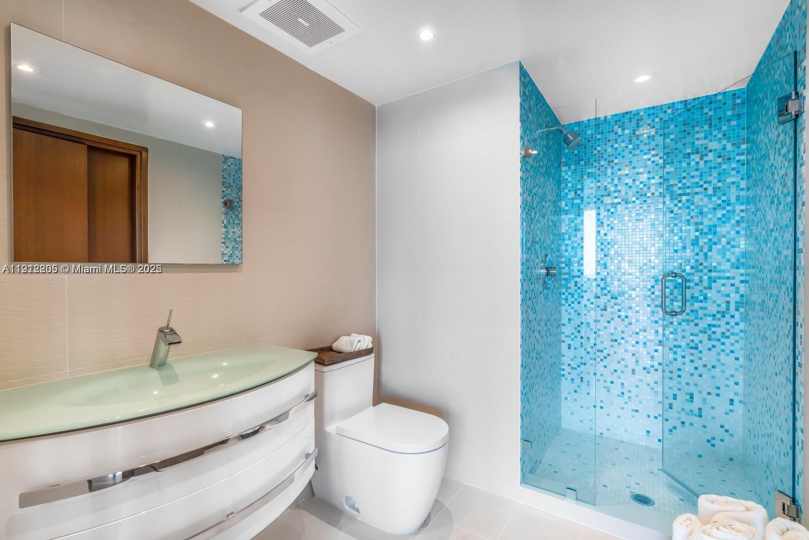 450 Alton Road, Unit 3303 Miami Beach, FL 33139 - Photo 15 of 35 a bathroom with a sink a toilet and shower
