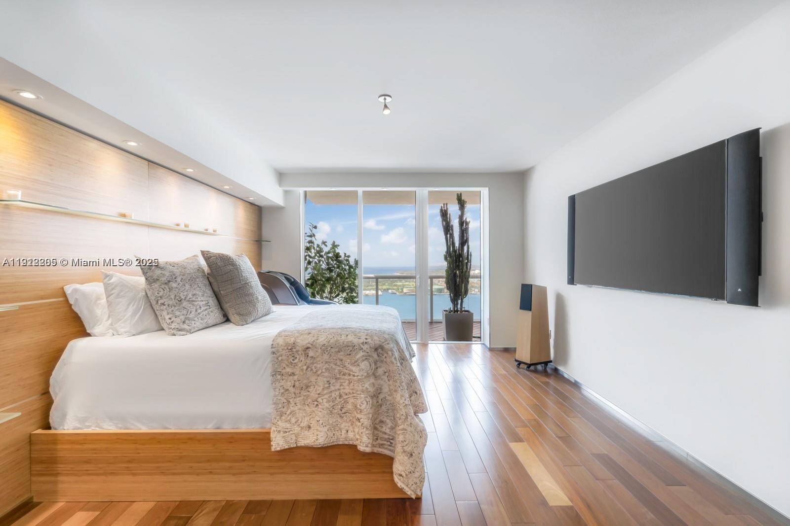 450 Alton Road, Unit 3303 Miami Beach, FL 33139 - Photo 18 of 35 a spacious bedroom with a large bed and a flat screen tv