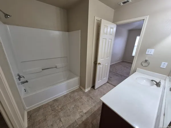 a bathroom with a bathtub sink and mirror