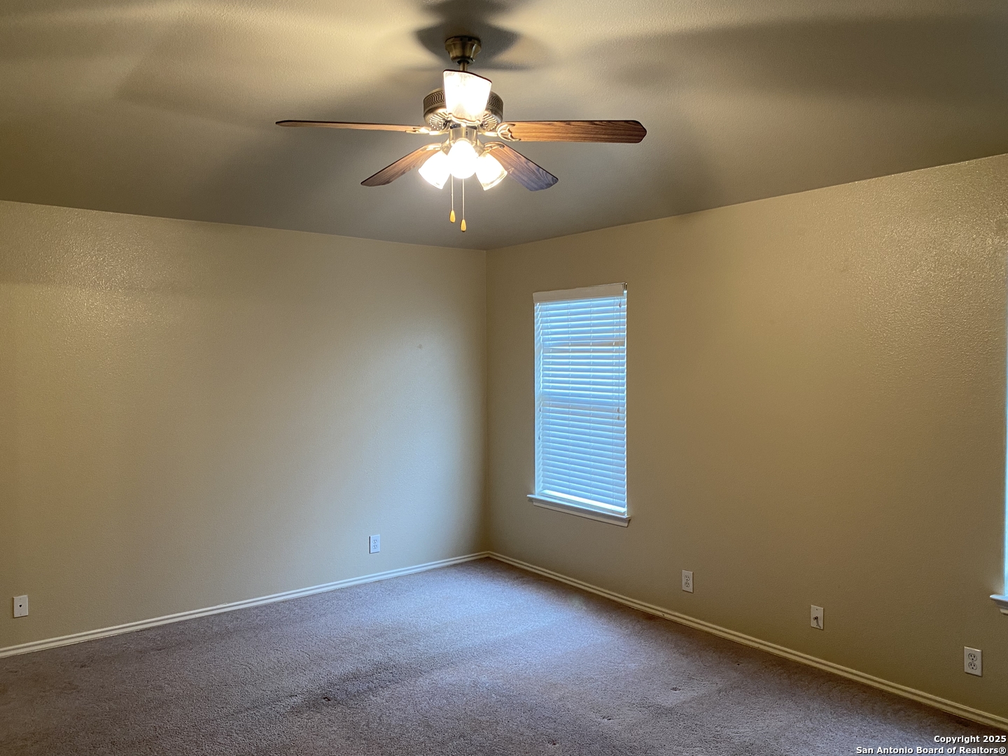 3338 Whisper Manor Schertz, TX 78108 - Photo 15 of 45 an empty room with a chandelier fan and windows