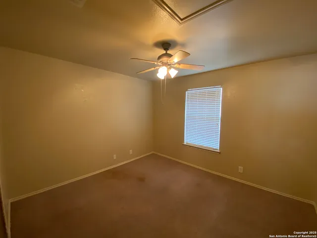 an empty room with a window and a fan