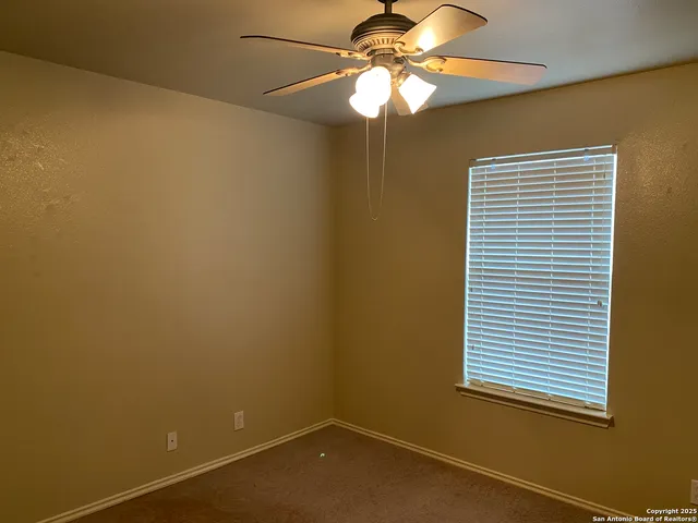 a view of a room with a chandelier fan