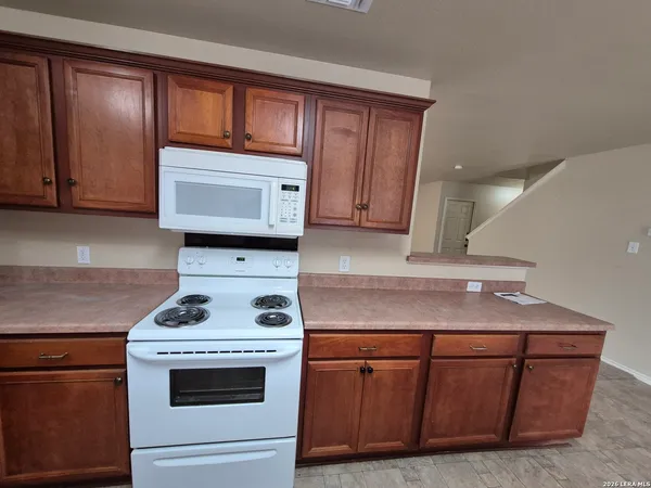 a kitchen with wooden cabinets and a stove top oven