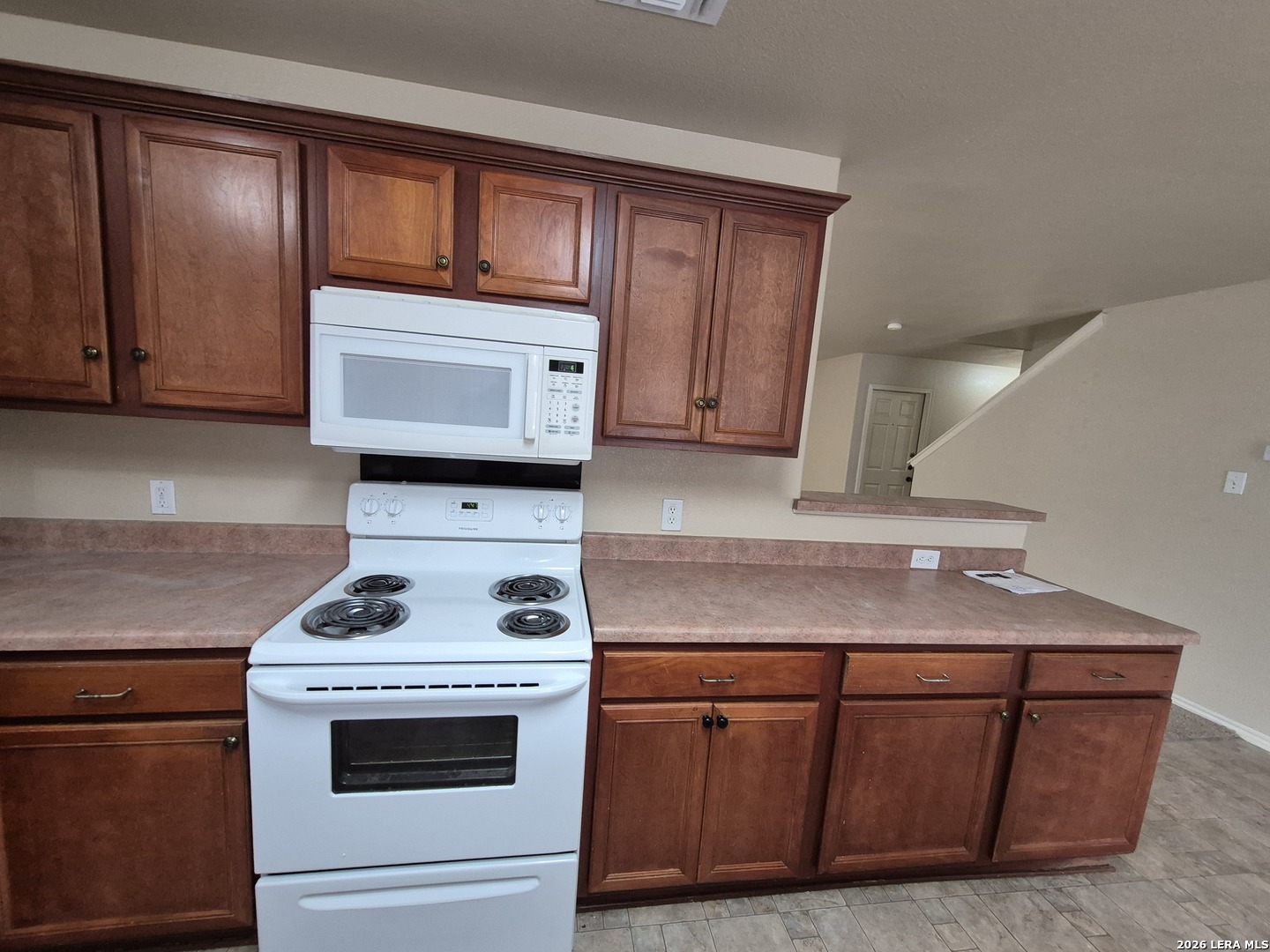 3338 Whisper Manor Schertz, TX 78108 - Photo 9 of 40 a kitchen with wooden cabinets and a stove top oven