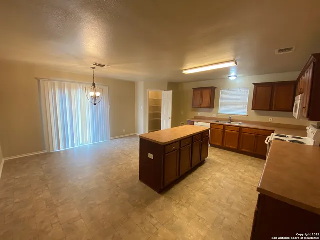 a kitchen with a wooden table and chairs