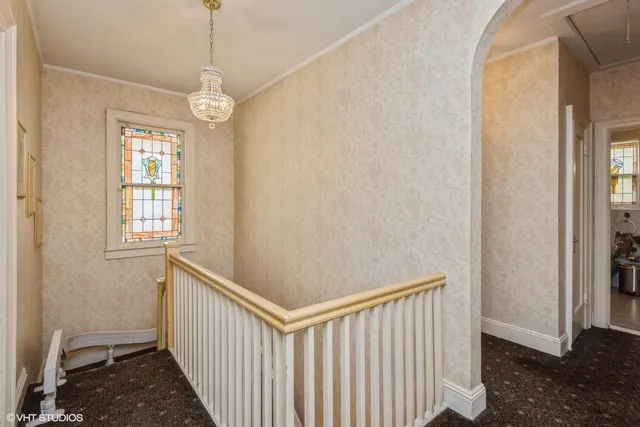 a bedroom with two beds and a chandelier