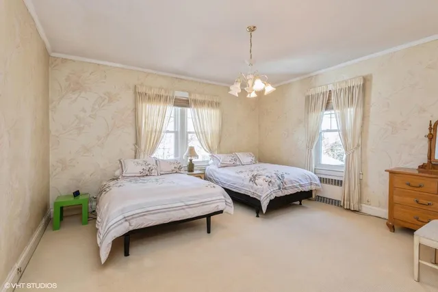 a bedroom with two beds and windows