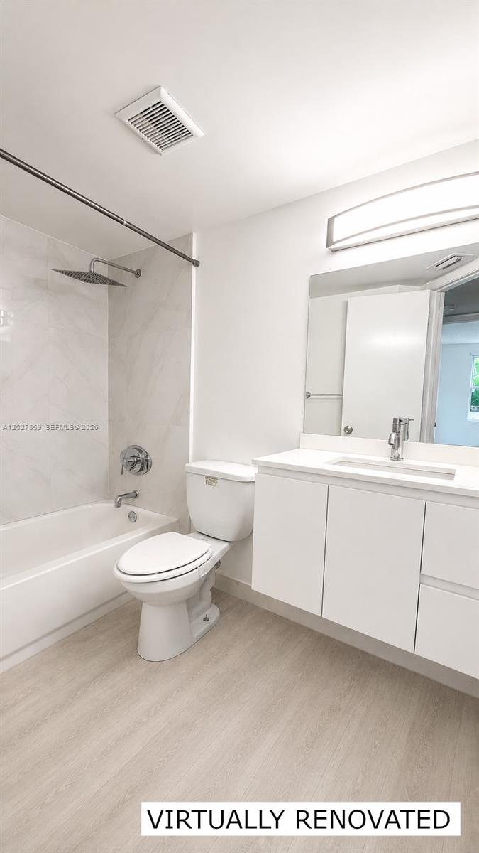 8761 Wiles Road, Unit 206 Coral Springs, FL 33067 - Photo 8 of 26 a bathroom with a toilet a sink a mirror and bathtub