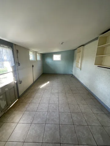a view of a livingroom with an empty space and a window