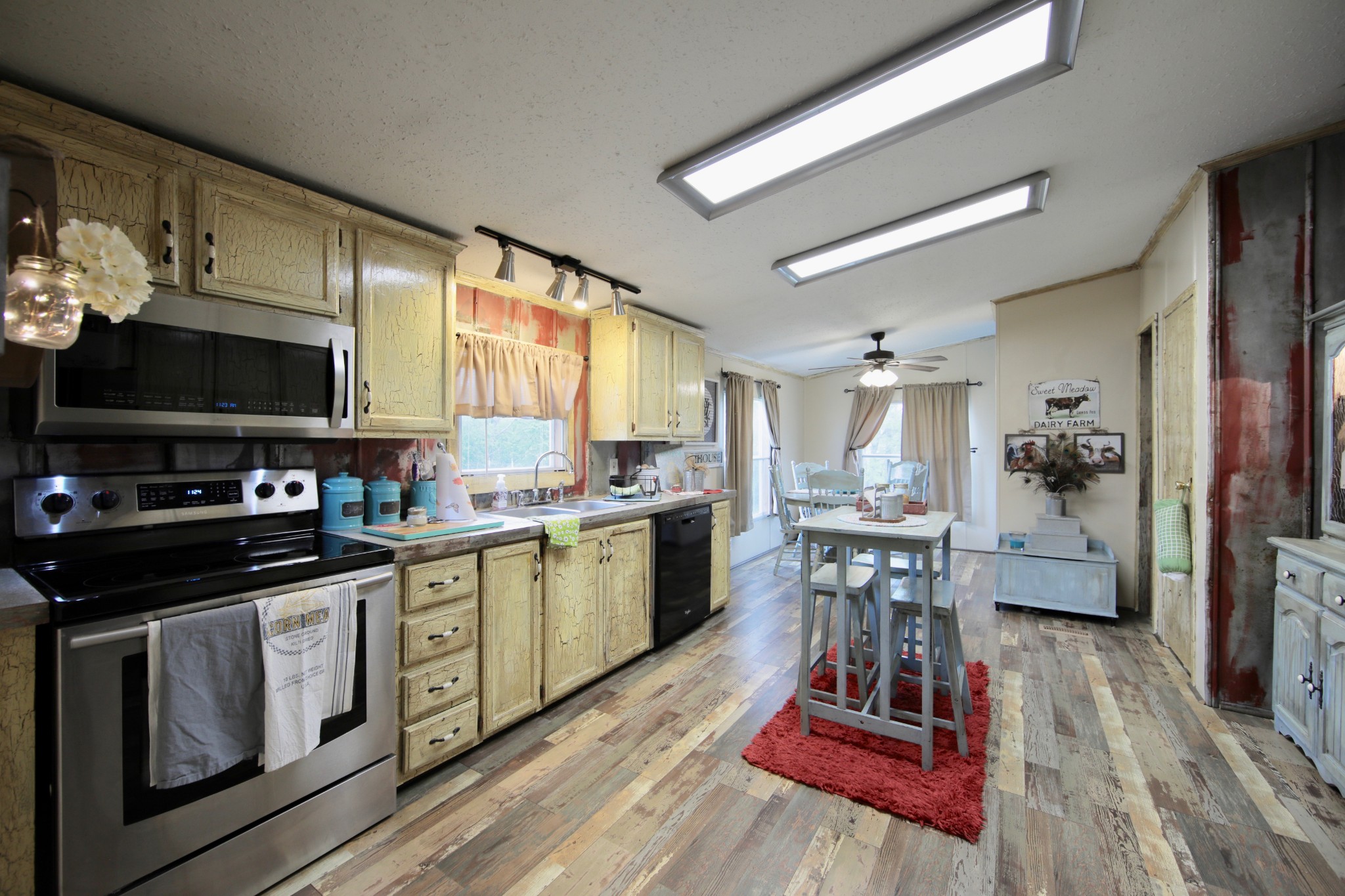 326 Ranch Road Portland, TN 37148 - Photo 4 of 30 a kitchen with stainless steel appliances a stove a sink dishwasher a microwave oven and a dining table with wooden floor