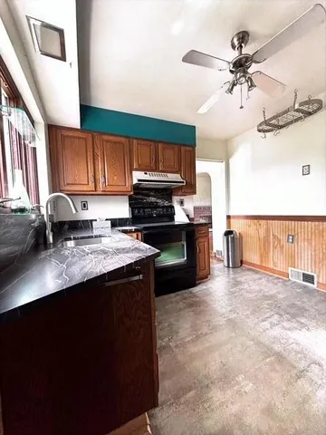 a kitchen with wooden cabinets and a stove top oven
