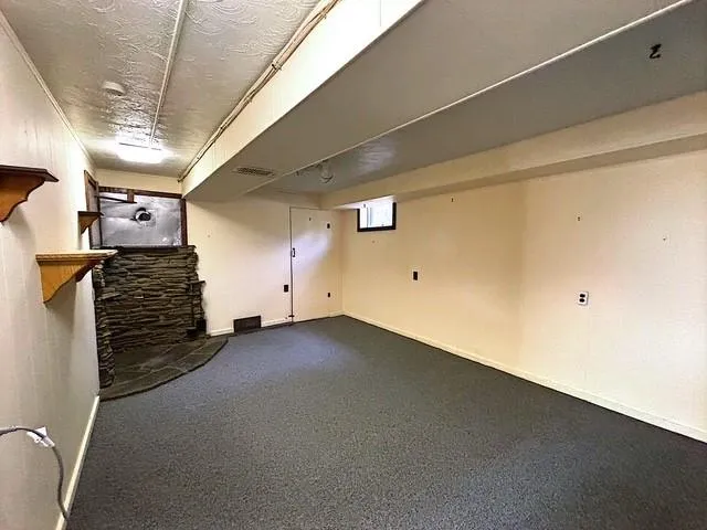 a bedroom with a bed a chair and potted plant on the dresser
