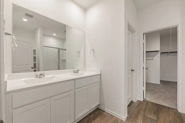 a bathroom with a double vanity sink mirror and shower