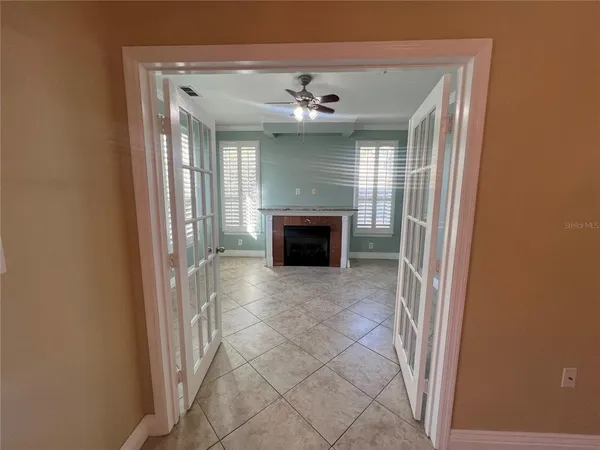 a view of an empty room with a fireplace and a window