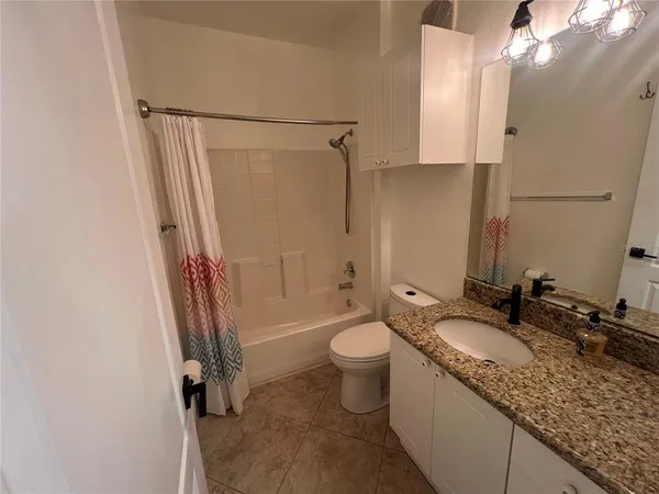 a bathroom with a granite countertop sink mirror vanity and toilet