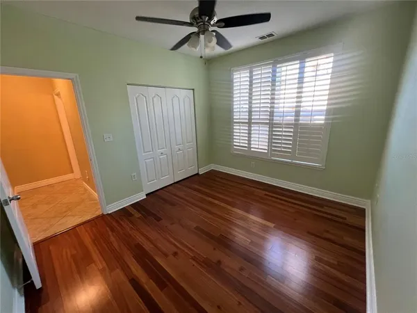 a view of an empty room with window and wooden floor