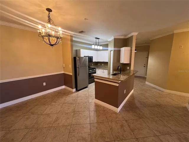 a kitchen with stainless steel appliances granite countertop a refrigerator a stove a sink and a microwave