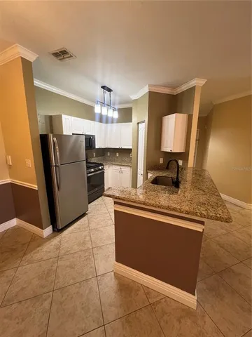 a kitchen with a refrigerator a sink and cabinets