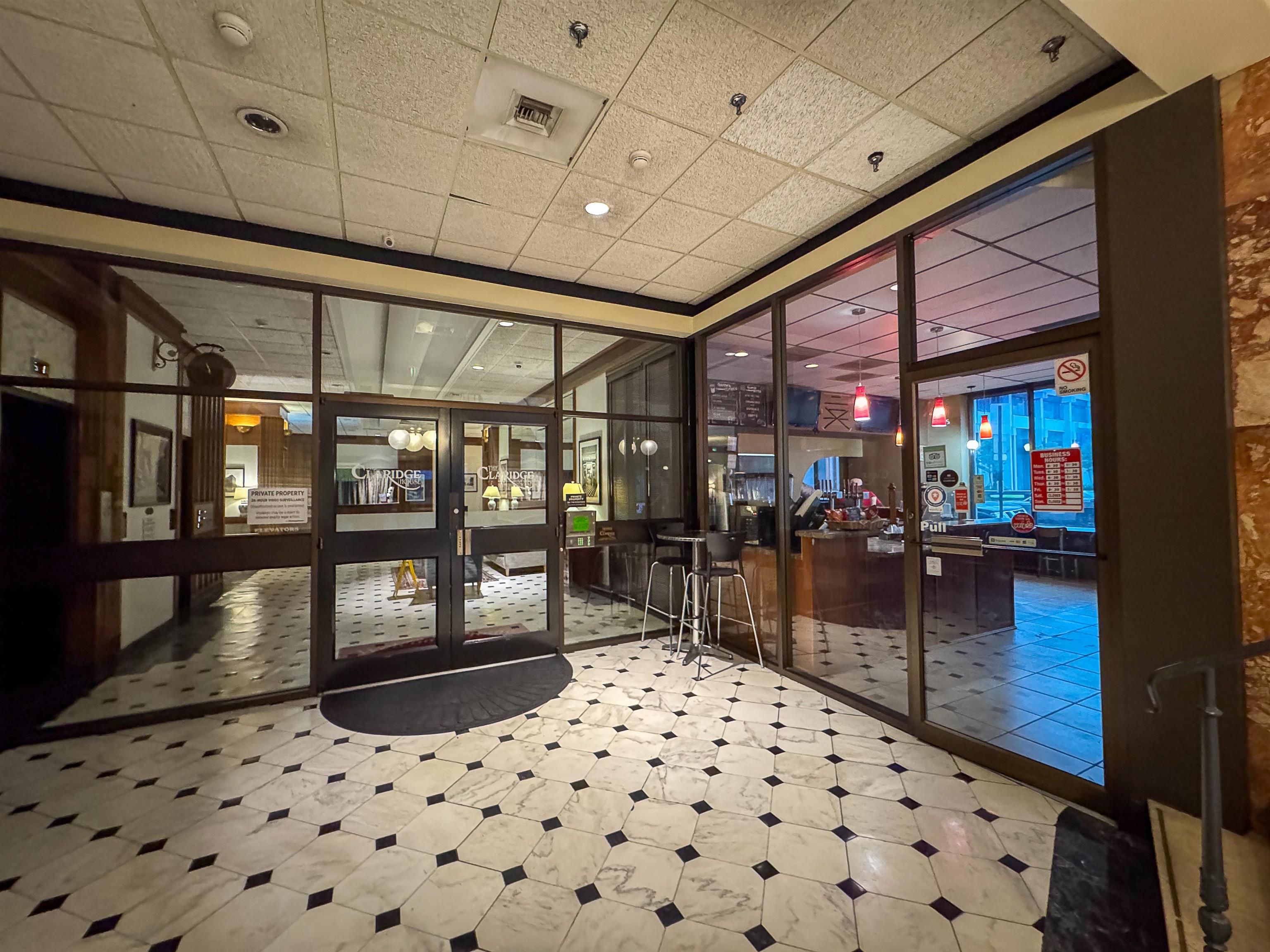 109 North Main Street, Unit 907 Memphis, TN 38103 - Photo 23 of 29 Lobby area featuring a patterned marble floor, full-height glass partitions, and a commercial space with a service counter