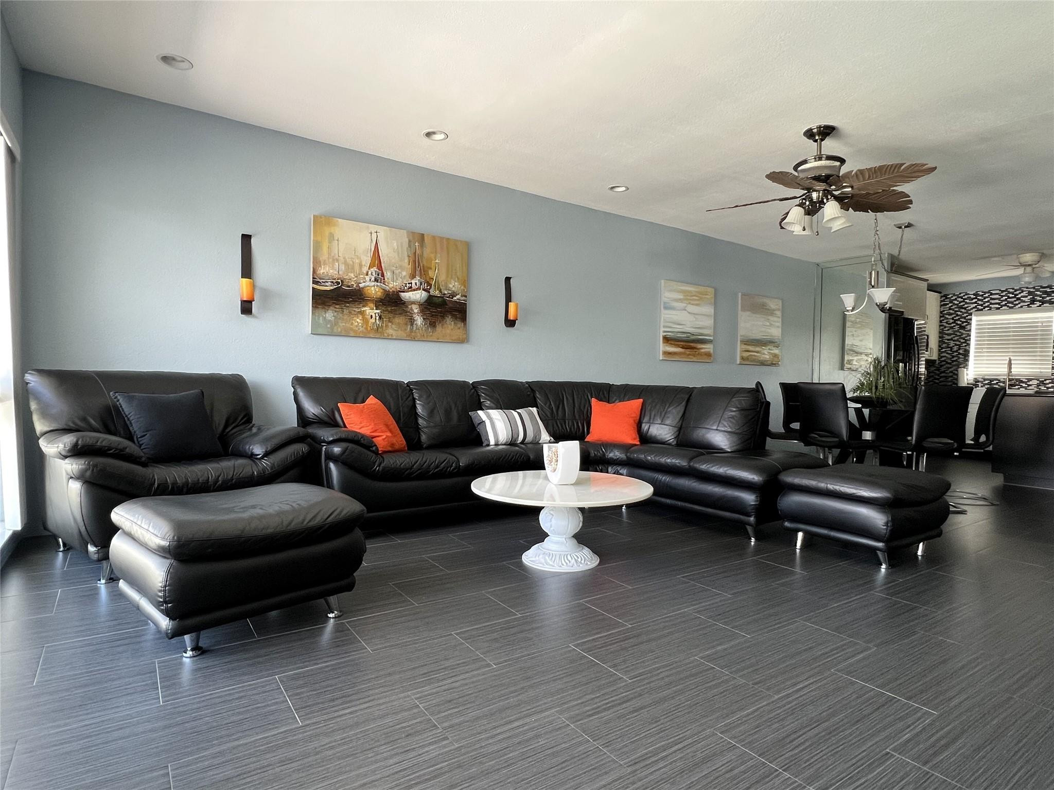 999 North Riverside Drive, Unit 9 Pompano Beach, FL 33062 - Photo 3 of 11 a living room with furniture a rug and a chandelier