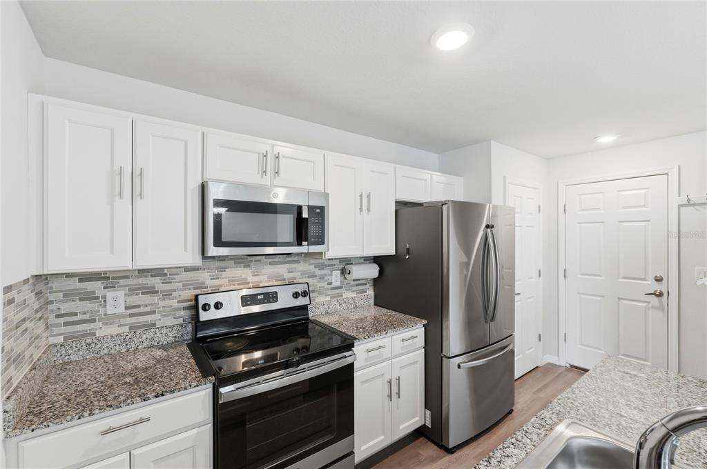 1637 Marble Street Sebring, FL 33870 - Photo 22 of 57 a kitchen with stainless steel appliances granite countertop a refrigerator stove and microwave