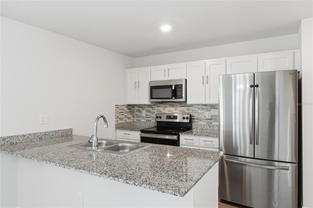 1637 Marble Street Sebring, FL 33870 - Photo 23 of 57 a kitchen with stainless steel appliances granite countertop a refrigerator a stove and a sink