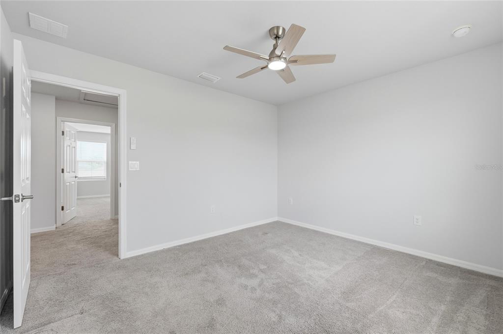 1637 Marble Street Sebring, FL 33870 - Photo 38 of 57 an empty room with a chandelier fan and windows